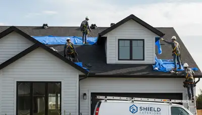 Roof repair crew fixing shingles on a Cincinnati, OH home exterior with new vinyl siding